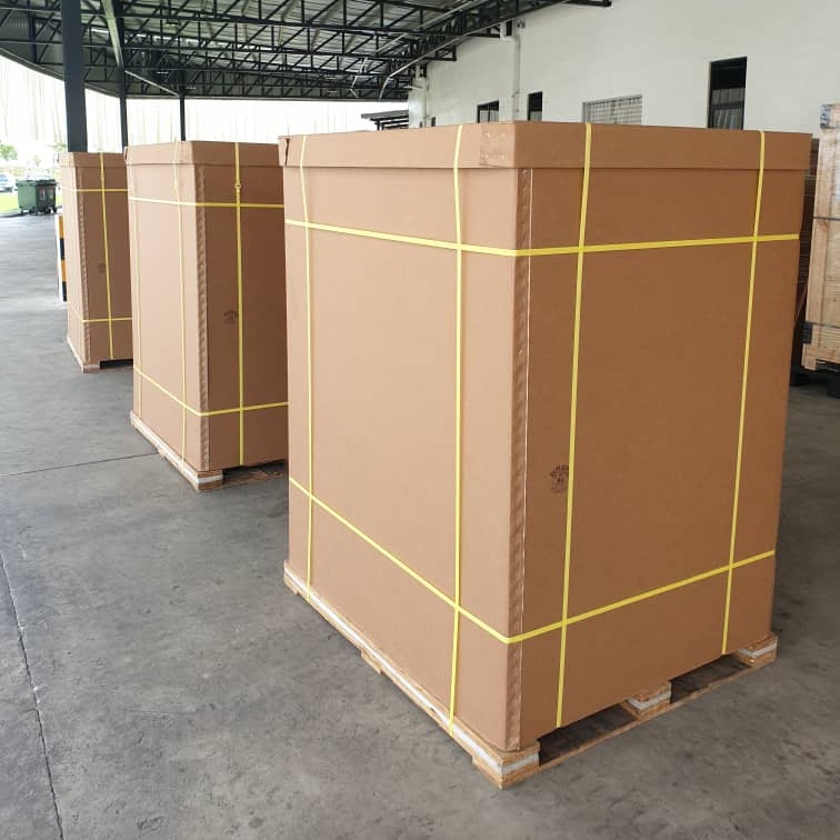Three large custom corrugated crates banded onto pallets in a warehouse